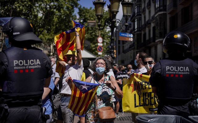 Manifestantes sostienen esteladas o banderas independentistas catalanas durante una protesta contra el primer ministro de España