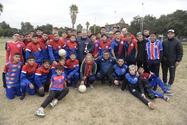 Alejandra Lescano, en el medio de los futbolistas y los profes de las divisiones inferiores del club San José.