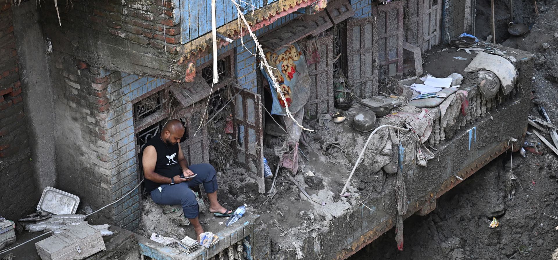 Un hombre se sienta en el balcón de su casa, dañada por las inundaciones repentinas que azotaron el país, Nuwakot, Nepal. Fotografía: Pedro Pardo/AFP/Getty Images Un hombre se sienta en el balcón de su casa, dañada por las inundaciones repentinas que azotaron el país, Nuwakot, Nepal. Fotografía: Pedro Pardo/AFP/Getty Images