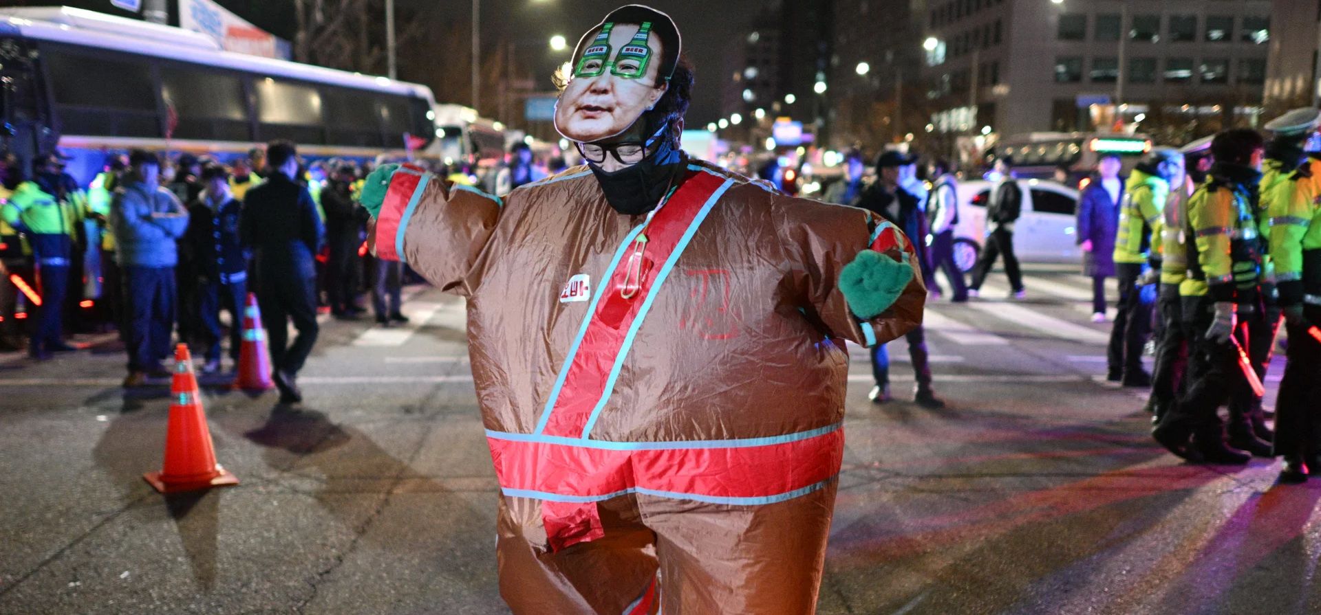 Un hombre vestido con un atuendo con una mascarilla del presidente de Corea del Sur, Yoon Suk Yeol, baila fuera de la asamblea nacional en Seúl. Fotografía: Anthony Wallace/AFP/Getty Images Un hombre vestido con un atuendo con una mascarilla del presidente de Corea del Sur, Yoon Suk Yeol, baila fuera de la asamblea nacional en Seúl. Fotografía: Anthony Wallace/AFP/Getty Images