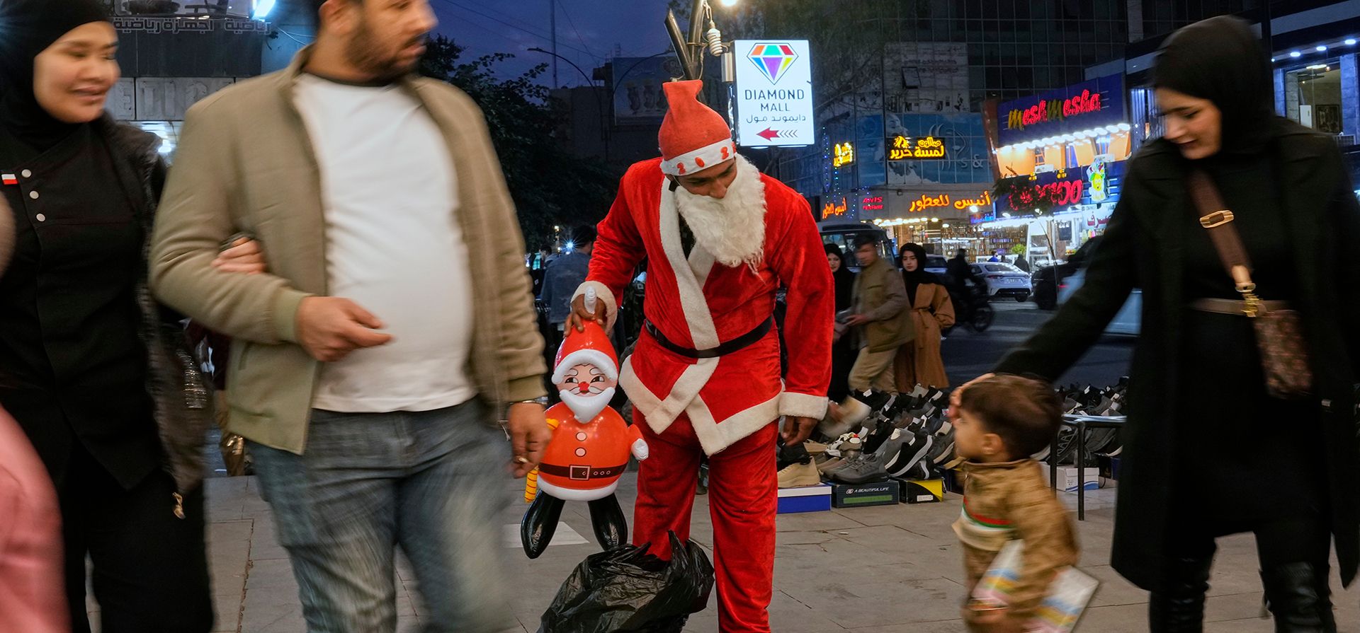 Un vendedor ambulante vestido de Papá Noel ofrece artículos y adornos navideños en Bagdad, Irak, el martes 23 de diciembre de 2025. (Foto AP/Hadi Mizban)