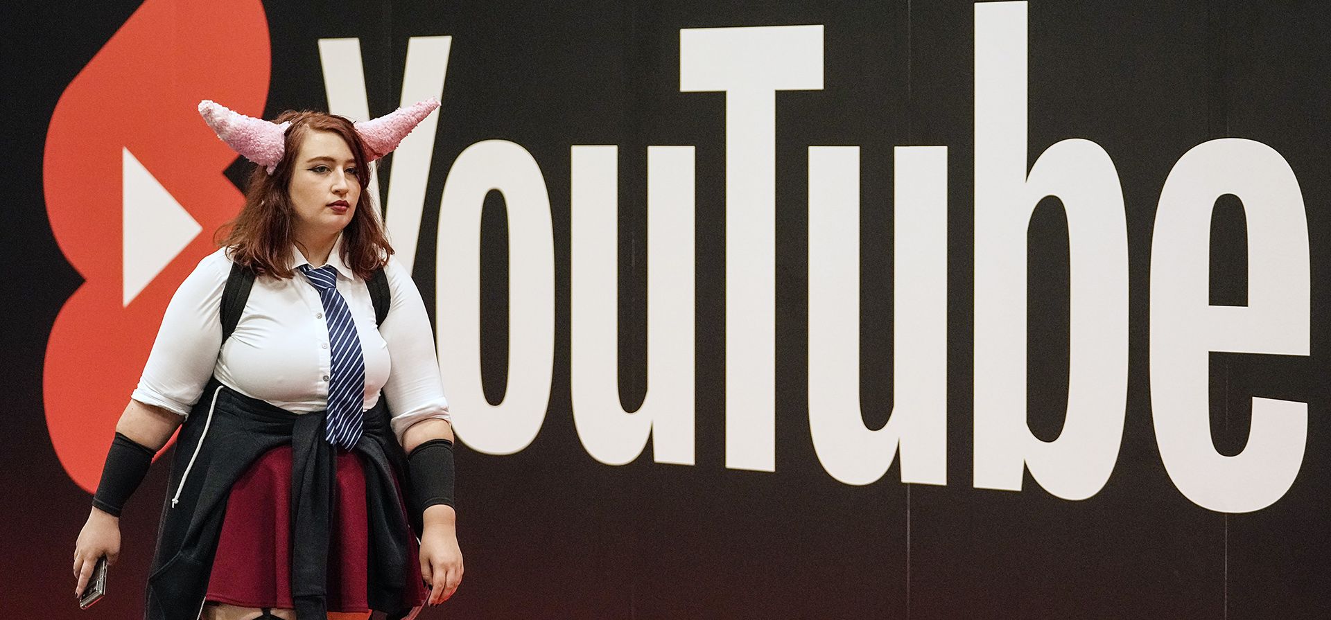 Un cosplayer camina en los puestos de exhibición de YouTube en la feria de juegos de computadora Gamescom en Colonia, Alemania. Alrededor de 1,100 expositores de 53 países esperan decenas de miles de entusiastas de los juegos diariamente por primera vez desde la pandemia de COVID-19 en el evento de juegos más grande del mundo.
