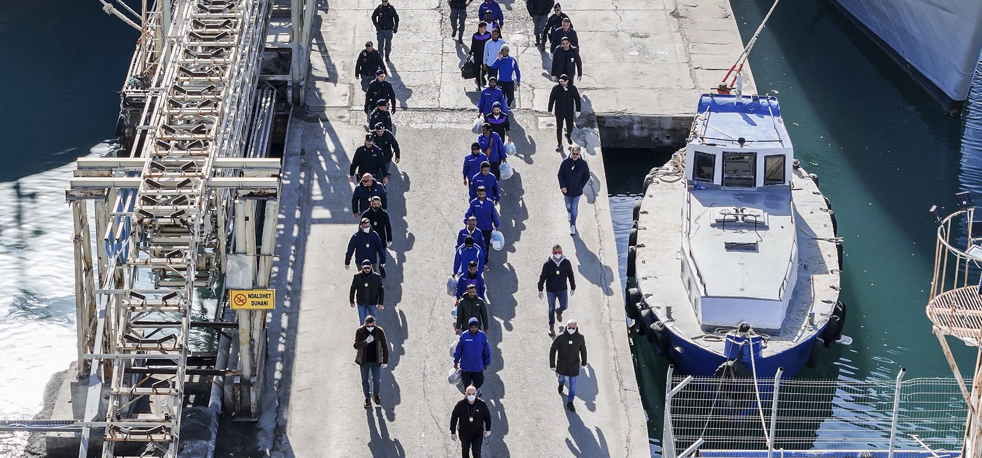 Una fotografía aérea tomada por un dron muestra a migrantes escoltados por la policía italiana en el camino a un proceso judicial tras rechazos anteriores, en el puerto de Shengjin, en el noroeste de Albania, el martes 28 de enero de 2025. (Foto AP/Vlasov Sulaj) Una fotografía aérea tomada por un dron muestra a migrantes escoltados por la policía italiana en el camino a un proceso judicial tras rechazos anteriores, en el puerto de Shengjin, en el noroeste de Albania, el martes 28 de enero de 2025. (Foto AP/Vlasov Sulaj)