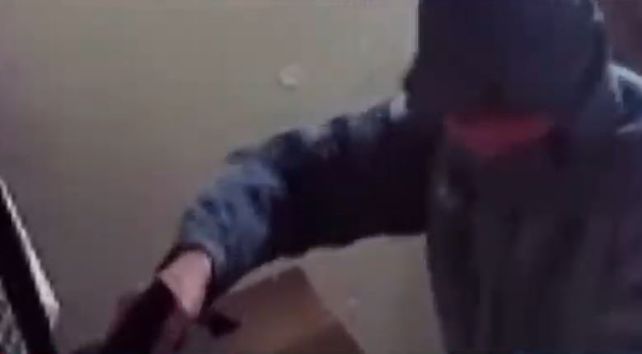 Uno de los ladrones apuntó al cajero para exigirle la suma de dinero.