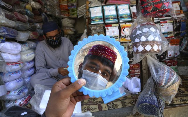 Un hombre se prueba un gorro tradicional en preparación para el próximo mes de ayuno musulmán del Ramadán
