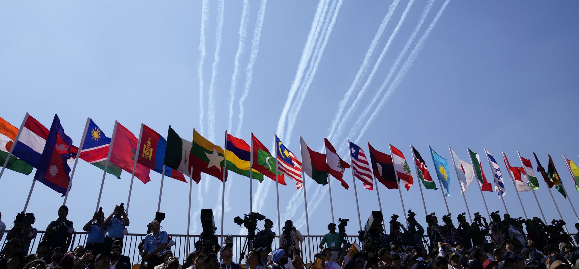 Las banderas de los países participantes se colocan en fila durante la inauguración de Aero India 2023 en la base aérea de Yelahanka en Bengaluru, India, el lunes 13 de febrero de 2023. Aero India es un evento bienal con demostraciones de vuelo de equipos de acrobacias y militares y pabellones comerciales donde las empresas de aviación exhiben sus productos y tecnología. (Foto AP/Aijaz Rahi)