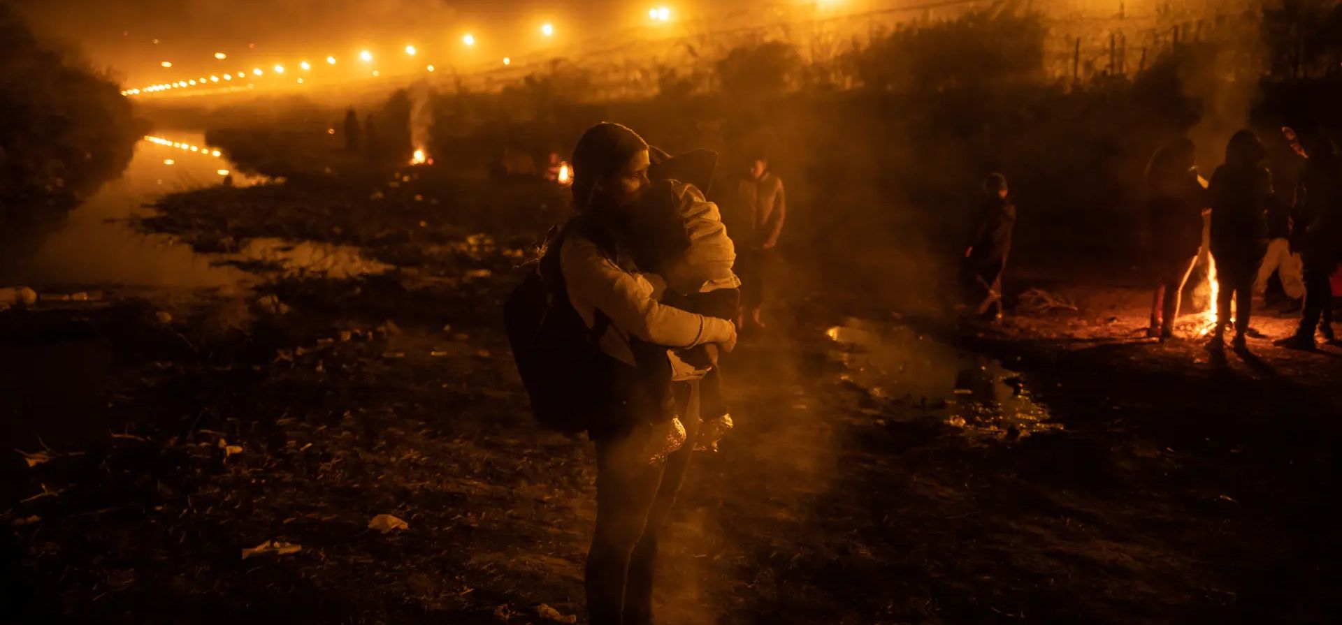 Stephani, una migrante venezolana de 28 años, sostiene a su hijo Estefan, de cuatro años, cerca de un incendio humeante a lo largo de un tramo seco del río Bravo después de llegar a un campamento de personas que buscan un punto de entrada a Estados Unidos. Río Grande, México. Fotografía: Adrees Latif/Reuters Stephani, una migrante venezolana de 28 años, sostiene a su hijo Estefan, de cuatro años, cerca de un incendio humeante a lo largo de un tramo seco del río Bravo después de llegar a un campamento de personas que buscan un punto de entrada a Estados Unidos. Río Grande, México. Fotografía: Adrees Latif/Reuters