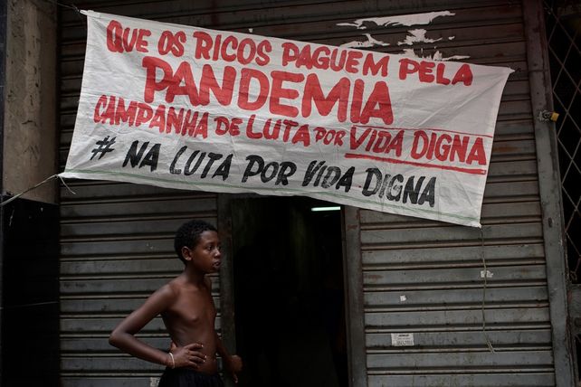 Un joven parado frente al ingreso de un edificio tomado por ocupantes en Río de Janeiro. (AP Photo/Silvia Izquierdo)