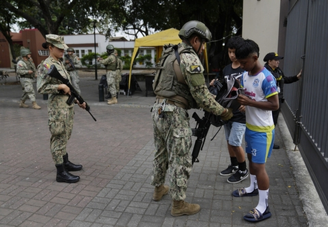 Militares controlan las mochilas de estudiantes secundarios en Guayaquil.