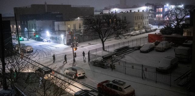 La gente cruza la calle durante una tormenta de nieve en la sección Ridgewood del distrito de Queens de Nueva York.