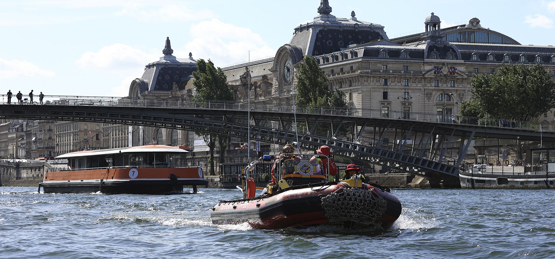 Un bote del equipo de rescate y una barcaza pasan por el museo de Orsay durante una prueba para la ceremonia de apertura de los Juegos Olímpicos de París 2024, el lunes 17 de julio de 2023 en París. (AP Photo/Aurelien Morissard) Un bote del equipo de rescate y una barcaza pasan por el museo de Orsay durante una prueba para la ceremonia de apertura de los Juegos Olímpicos de París 2024, el lunes 17 de julio de 2023 en París. (AP Photo/Aurelien Morissard)