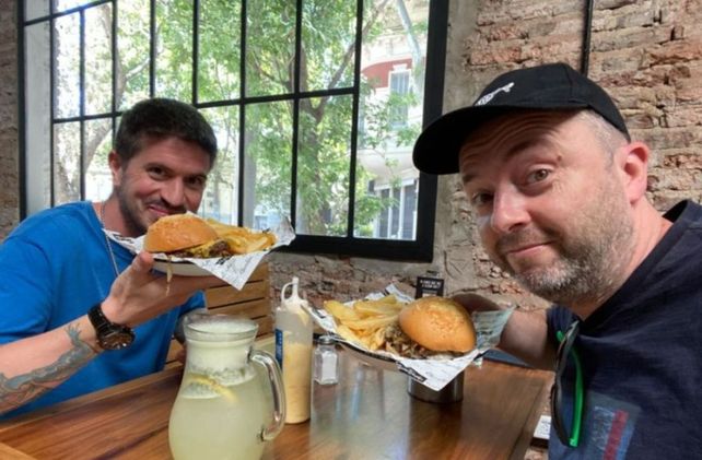 Sir Chandler (derecha) almuerza con un amigo en un bar de Rosario durante su visita de este verano