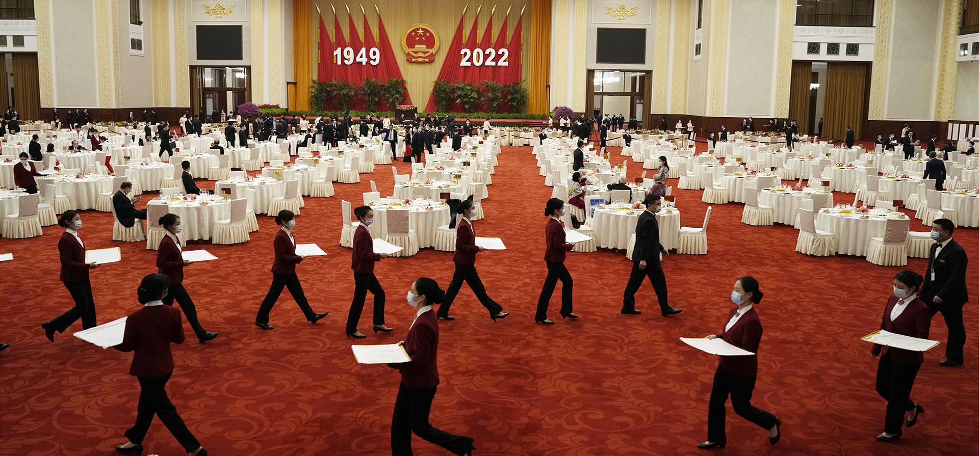 Camareras y meseros se preparan para una cena de recepción en el Gran Salón del Pueblo en la víspera del feriado del Día Nacional en Beijing, el viernes 30 de septiembre de 2022.