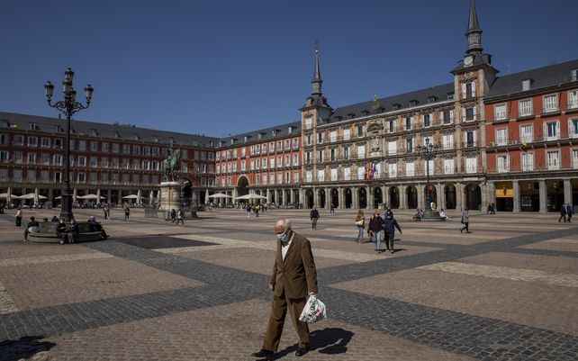 Un persona camina por la Plaza Mayor en el centro de Madrid