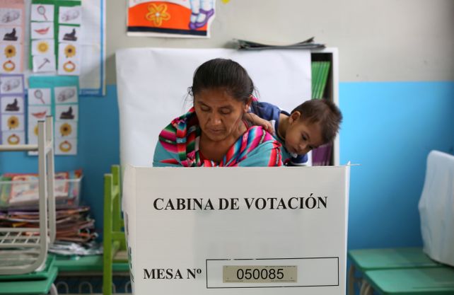 Madre e hijo en la cabina de voto.