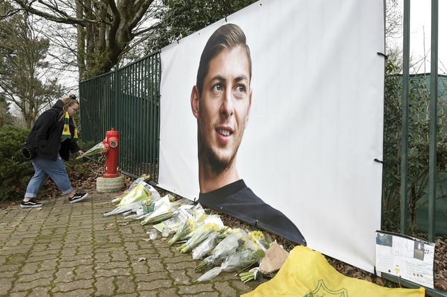 Dolor. Una mujer coloca flores ante una imagen de Sala en Nantes.