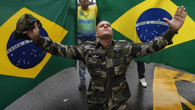 Un militar hace sus oraciones frente a una bandera pidiendo al intervención de los cuarteles en Brasil.&nbsp;