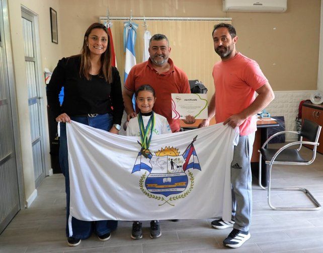 La joven campeona sudamericana junto a sus padres y el intedendente de Oro Verde.