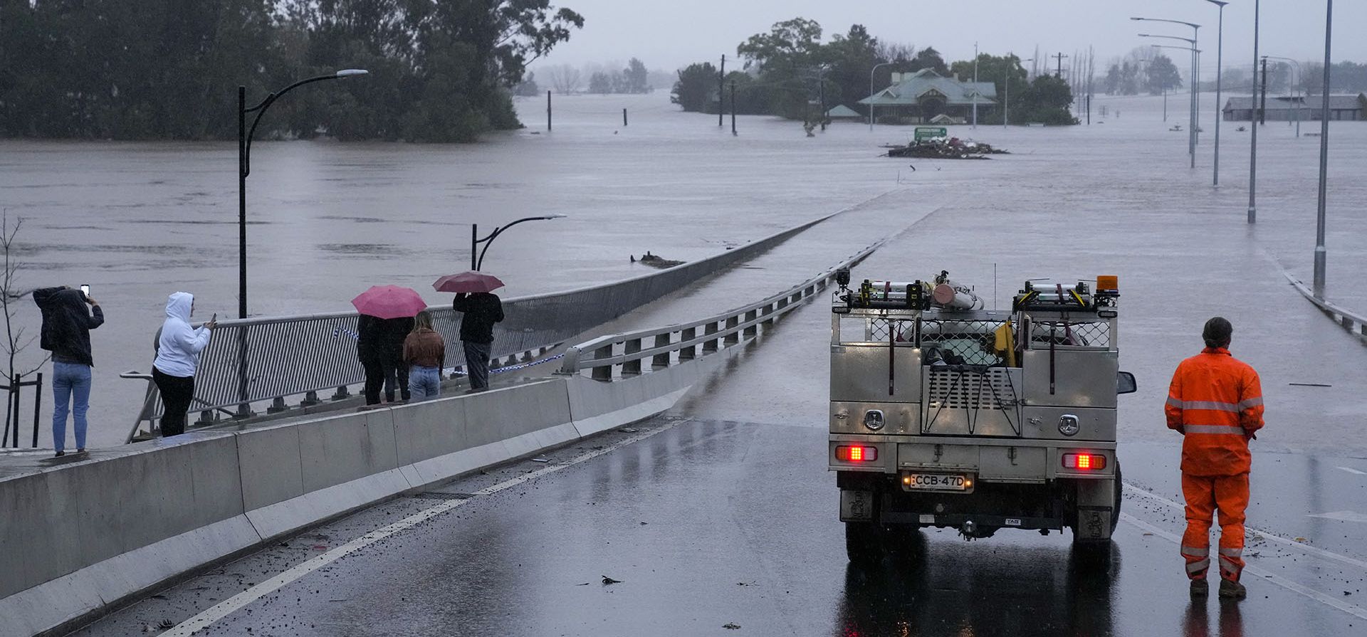 Un vehículo de emergencia bloquea el acceso al puente Windsor inundado en las afueras de Sídney, Australia, el lunes 4 de julio de 2022. Más de 30.000 residentes de Sídney y sus alrededores recibieron instrucciones de evacuar o prepararse para abandonar sus hogares el lunes, la ciudad se prepara para lo que podría ser su peor inundación en 18 meses.