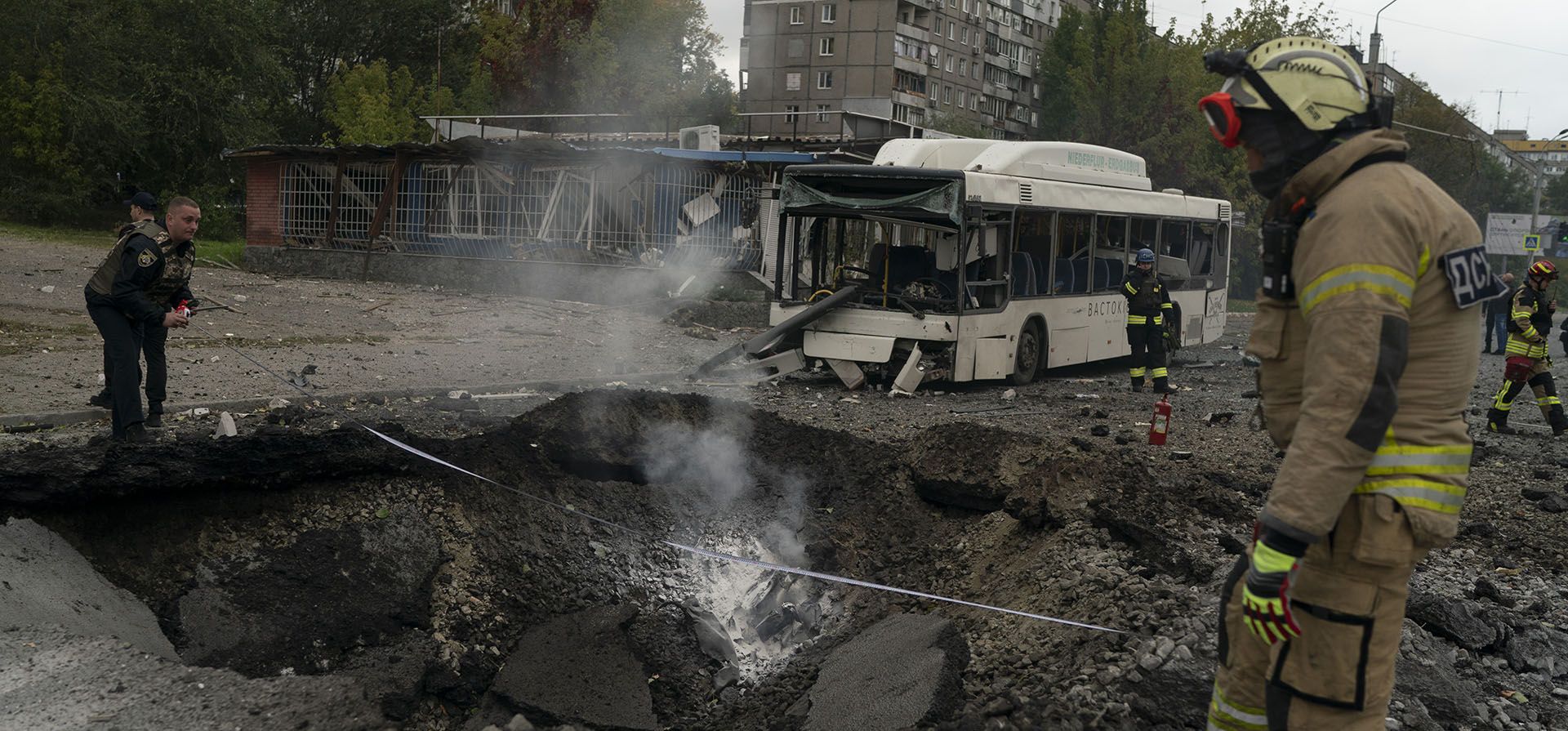 Bomberos y policías trabajan en un sitio donde una explosión creó un cráter en la calle después de un ataque ruso en Dnipro, Ucrania, el lunes 10 de octubre de 2022.