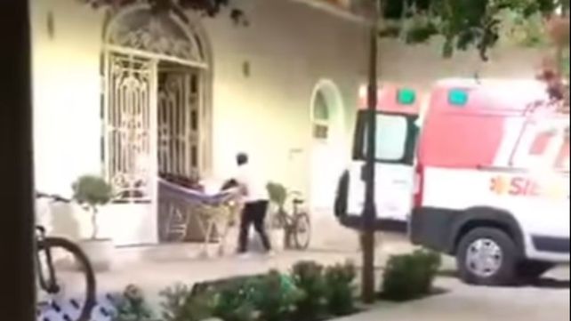 Momento en que personal de una ambulancia retira en camilla a una mamá herida durante el acto escolar (Imagen de video).&nbsp;