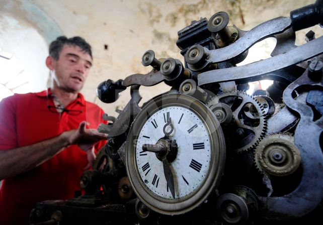 Limpieza. Un operario de la empresa lleva adelante la refacción del antiguo reloj de la parroquia.