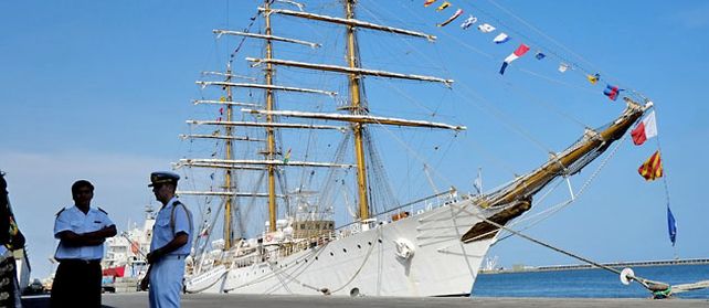 Dos oficiales delante del navío escuela argentino retenido por un reclamo de fondos buitres.