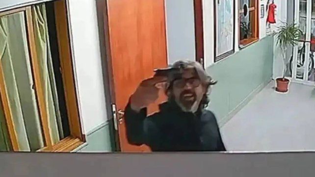 Alberto Ariaudo mostrando el arma de fuego a una cámara de seguridad.