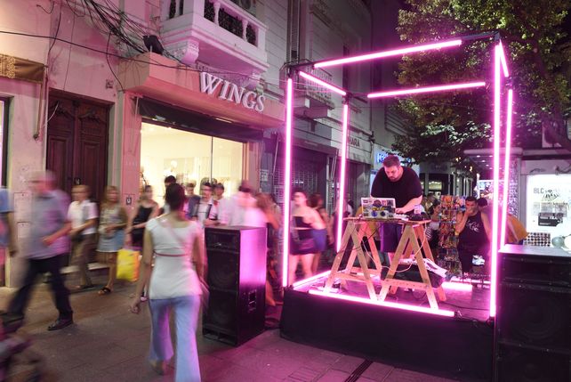 Un DJ en medio de una plataforma de neón anima en calle Córdoba La Noche de Peatonales.