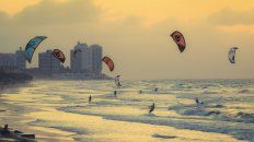 Una playa llena de personas haciendo kitesurf, deporte patentado en 1977 por Gijsbertus Adrianus Panhuise. Una playa llena de personas haciendo kitesurf, deporte patentado en 1977 por Gijsbertus Adrianus Panhuise.