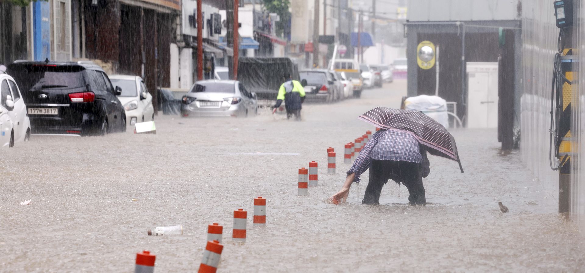 La gente camina por una calle inundada debido a las fuertes lluvias en Gwangju, Corea del Sur, el jueves 17 de julio de 2025. (Jeong Da-eum/Yonhap vía AP) La gente camina por una calle inundada debido a las fuertes lluvias en Gwangju, Corea del Sur, el jueves 17 de julio de 2025. (Jeong Da-eum/Yonhap vía AP)