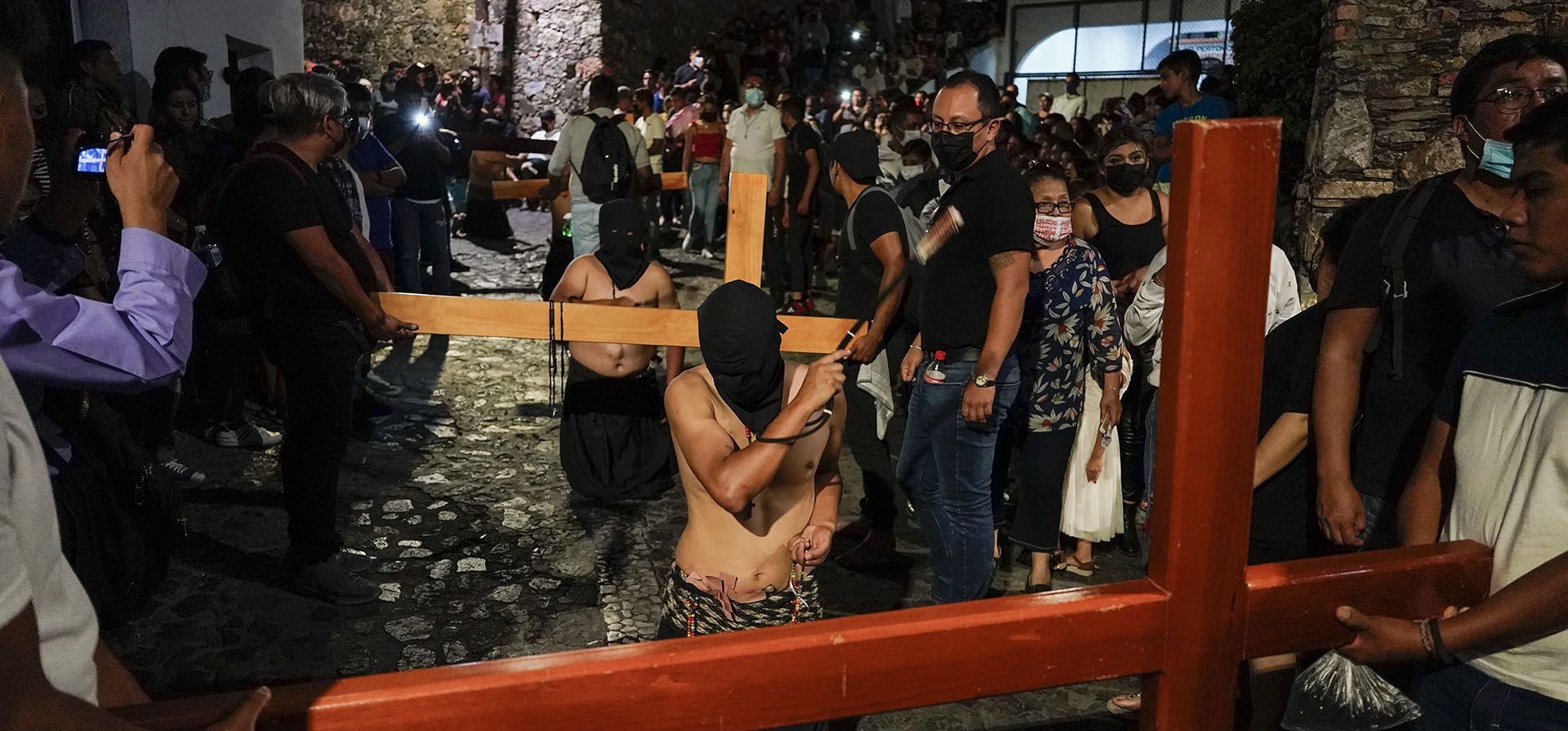 Los penitentes cargan cruces y látigos con clavos mientras caminan en una procesión de Semana Santa en Taxco, México, el jueves 14 de abril de 2022.