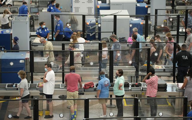 Pasajeros en la fila del puesto de control de seguridad norte en la terminal principal del Aeropuerto Internacional de Denver esperan para recoger sus pertenencias después de pasar por los controles de imagen.