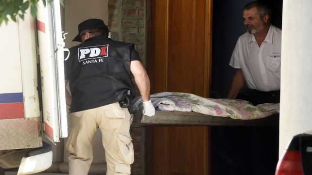 El cuerpo de una de las víctimas es retirado de la casa de Pago Largo 654 donde lo mataron.