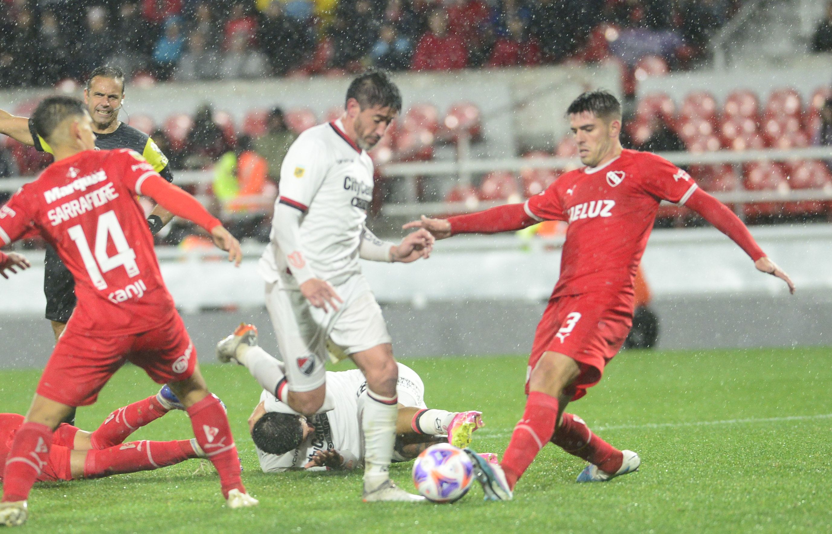 Pablo Pérez traslada el balón entre Elizalde y Sarrafiore. El volante cumplió en su retorno a la titularidad.