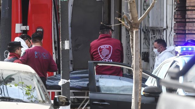 Personal policial retira uno de los cuerpos del domicilio del barrio porteño de Almagro donde un ciudadano chico asesinó a sus suegros.  