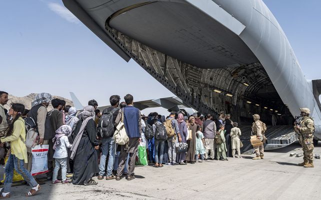 Miembros de la Fuerza Aérea de EE. UU y Marines guían a los evacuados a bordo de un C-17 Globemaster III de la Fuerza Aérea. En apoyo de la evacuación de Afganistán en el Aeropuerto Internacional Hamid Karzai en Kabul