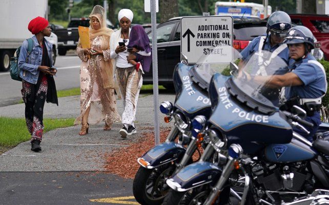 Tres mujeres pasan junto a los policías del estado de Massachusetts frente al Tribunal de Distrito de Malden, en Medford, Massachusetts.