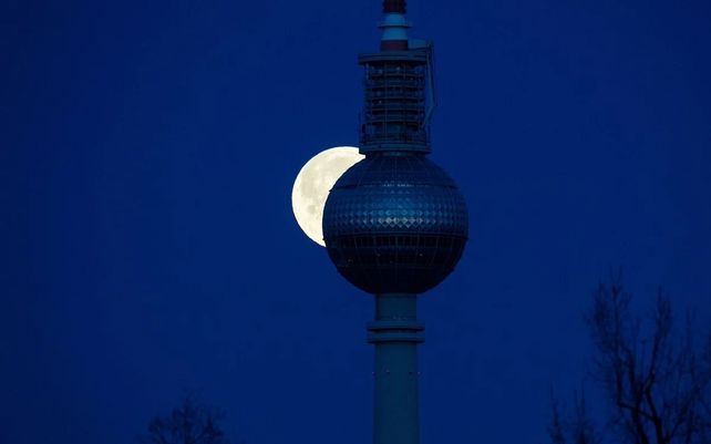 La Luna Super Rosa sale detrás de una torre de televisión en Berlín.