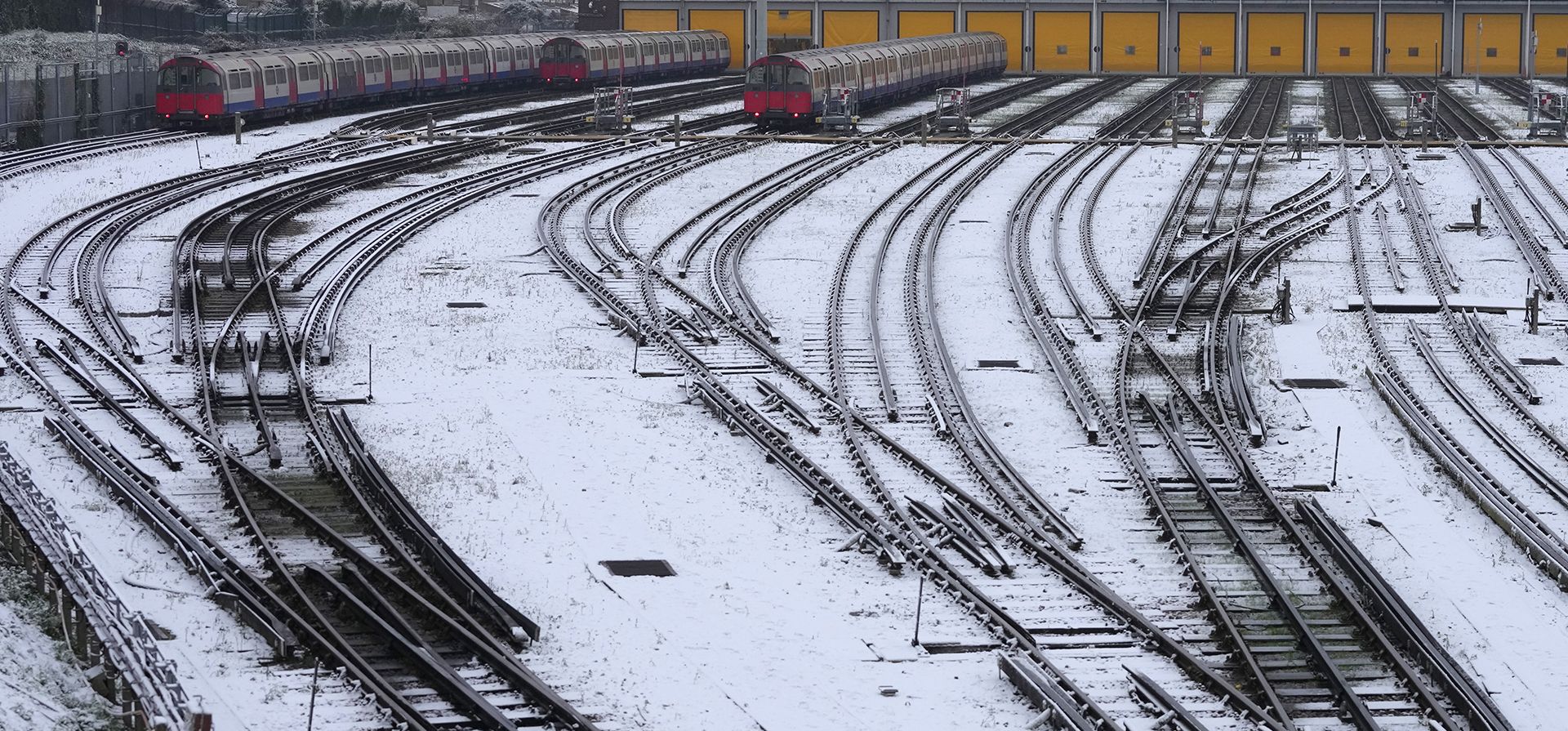 La nieve cubre las vías mientras los trenes subterráneos están estacionados en Londres, el lunes 12 de diciembre de 2022. (Foto AP/Kirsty Wigglesworth)