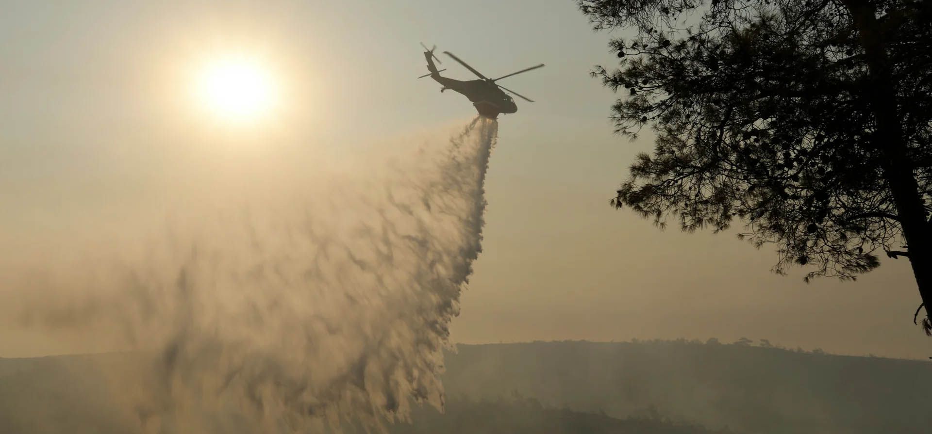 Un helicóptero arroja agua sobre un bosque quemado durante un incendio forestal masivo en el lado sur de la cordillera de Troodos, Pueblo de Souni, Chipre. Fotografía: Petros Karadjias/AP Un helicóptero arroja agua sobre un bosque quemado durante un incendio forestal masivo en el lado sur de la cordillera de Troodos, Pueblo de Souni, Chipre. Fotografía: Petros Karadjias/AP