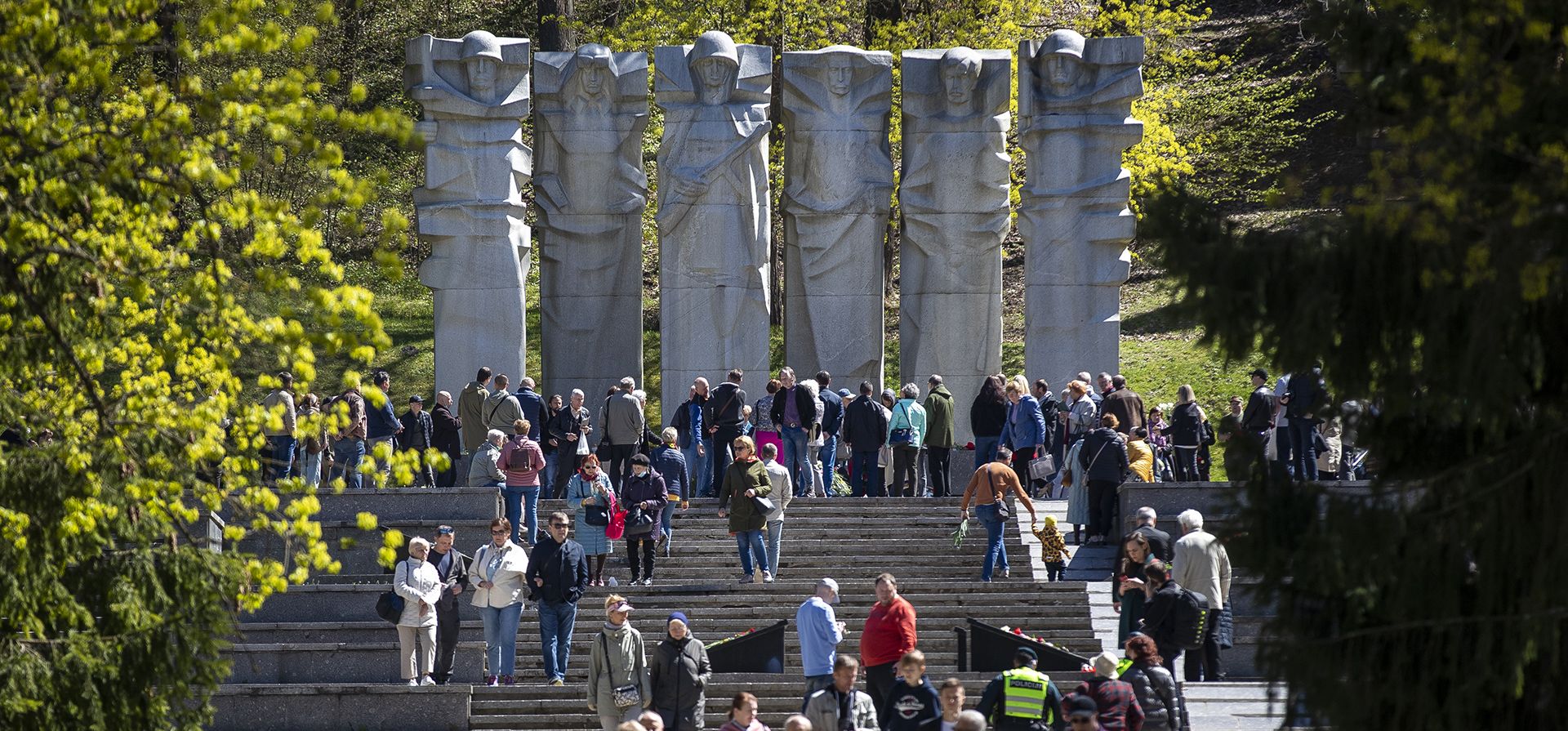 Visitantes caminan cerca de la tumba del Soldado Desconocido durante una ceremonia conmemorativa que marca el 77 aniversario del fin de la Segunda Guerra Mundial en el memorial Antakalnis en Vilnius, Lituania, el lunes 9 de mayo de 2022.