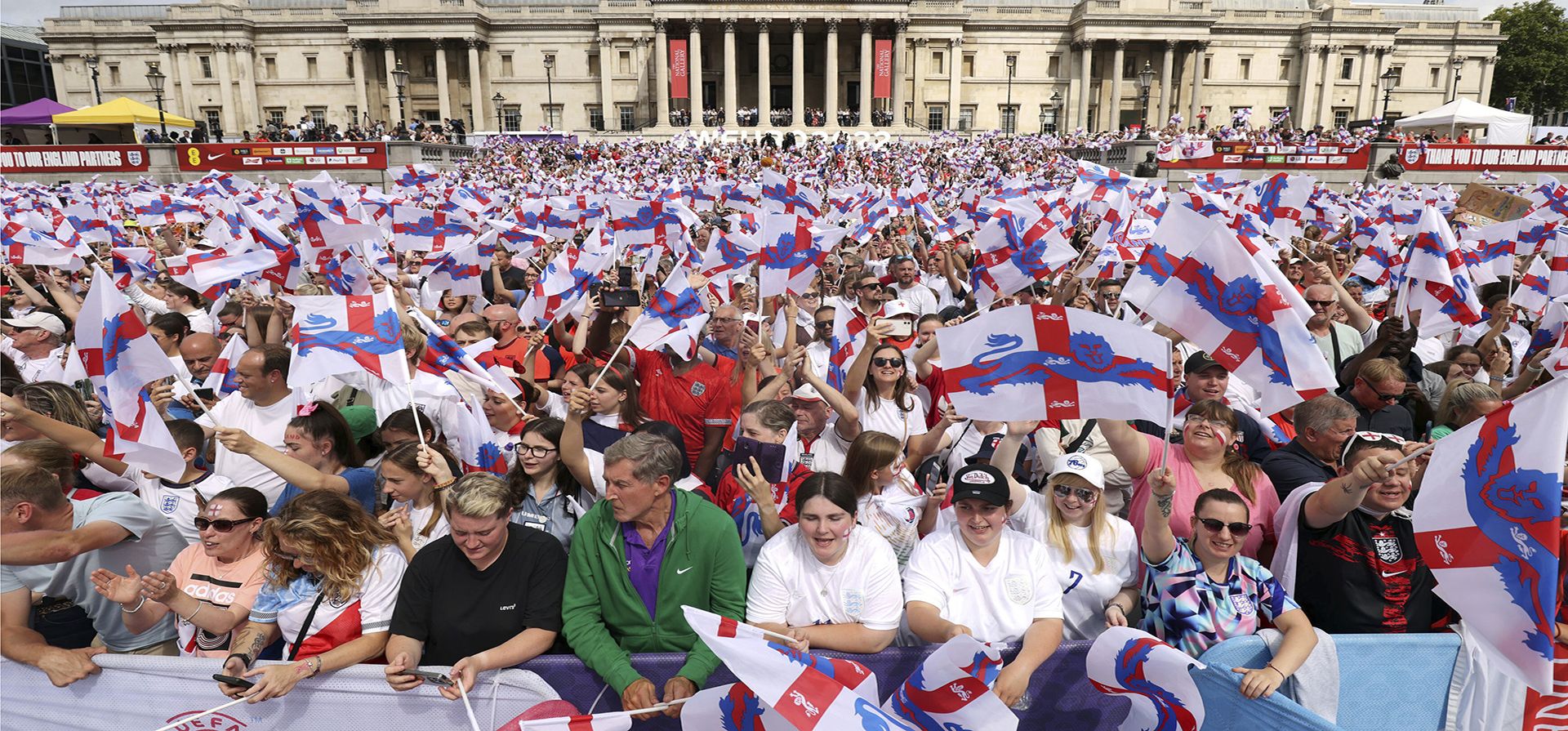 Seguidores de Inglaterra ondean banderas mientras esperan la llegada de su selección nacional de fútbol femenino a Trafalgar Square en Londres, el lunes 1 de agosto de 2022. Inglaterra venció a Alemania 2-1 y ganó la final de la Eurocopa Femenina 2022 el domingo.