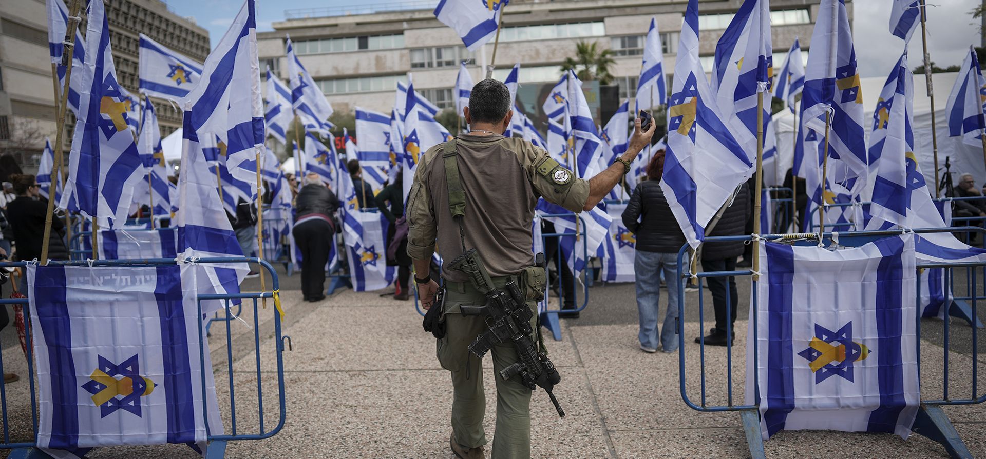 Un soldado israelí sostiene su teléfono celular mientras camina hacia la Un soldado israelí sostiene su teléfono celular mientras camina hacia la