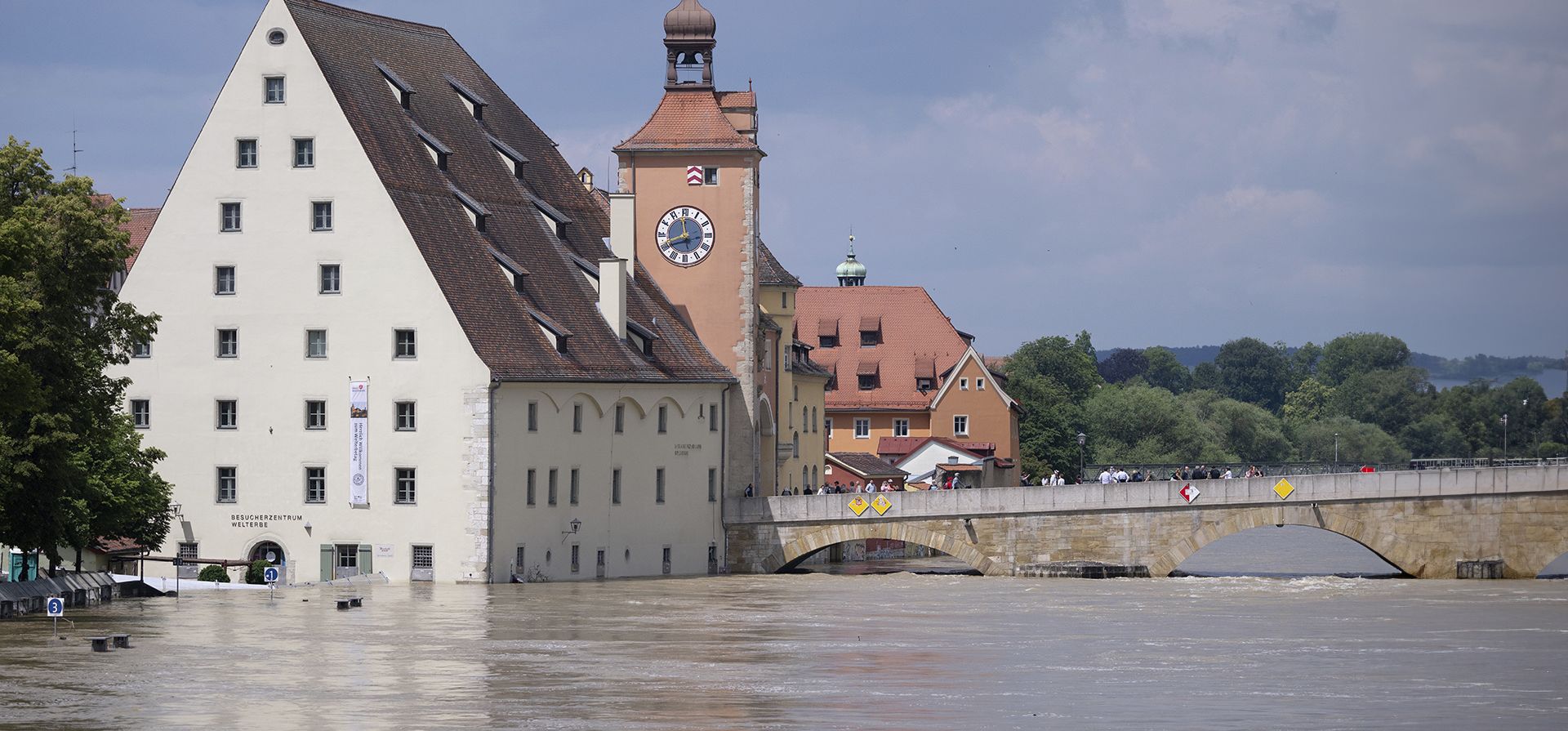 La gente observa desde el Puente de Piedra, en el casco antiguo, las inundaciones en el Danubio, en Ratisbona, Alemania, el miércoles 5 de junio de 2024. Los ayudantes en Baviera han estado luchando contra la inundación y sus consecuencias durante días. (Sven Hoppe/dpa vía AP)