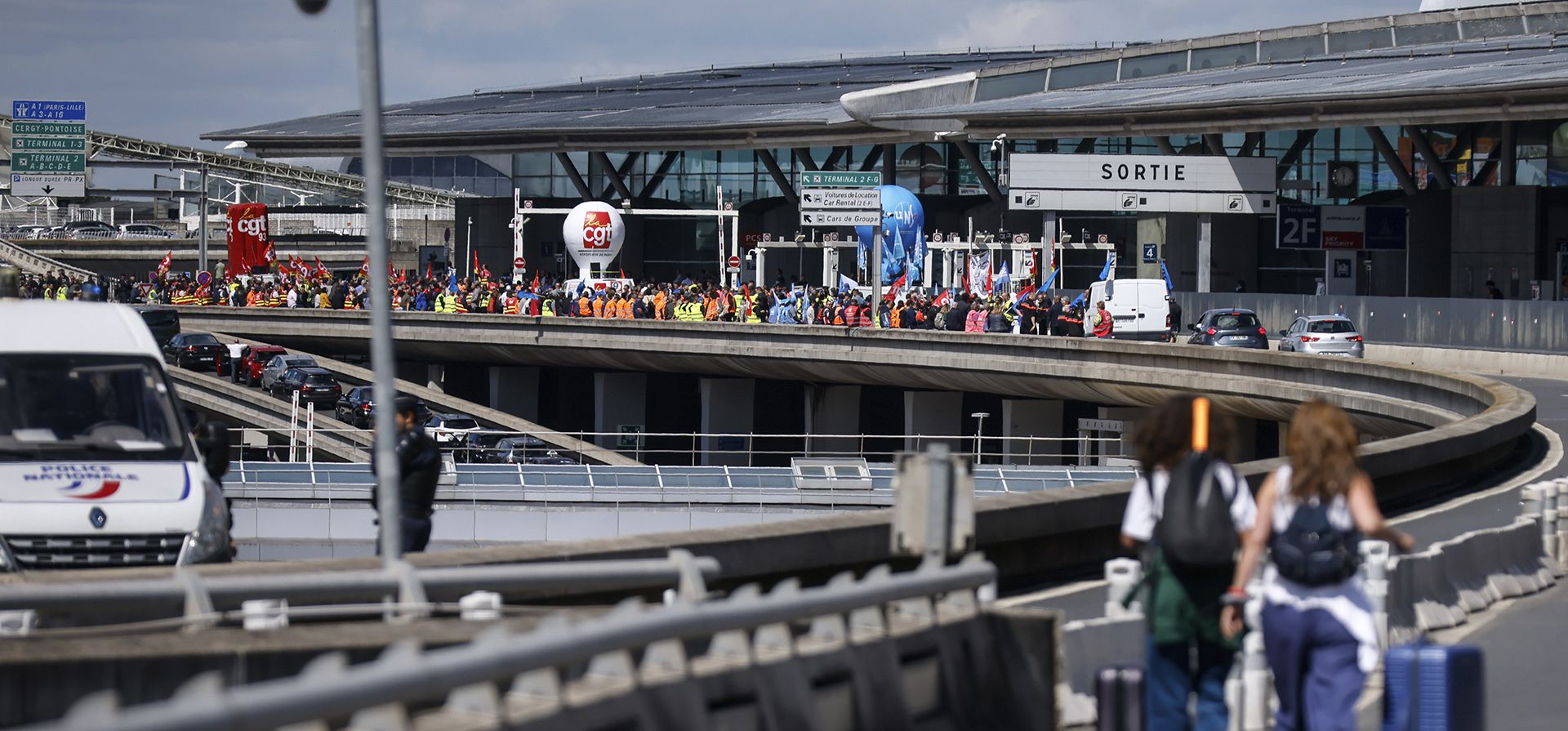 Los viajeros llegan a pie al aeropuerto de Roissy-Charles de Gaulle mientras los trabajadores del aeropuerto realizaron una huelga y protestas para exigir aumentos salariales para mantenerse al día con la inflación, el viernes 1 de julio de 2022 en el aeropuerto de Roissy, al norte de París.
