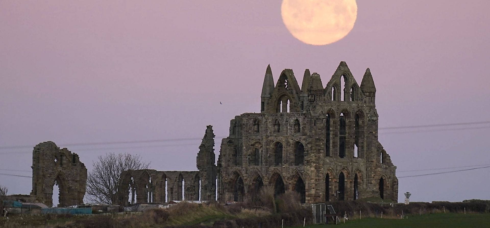 La luna se pone detrás de Whitby Abbey en Yorkshire, Inglaterra, el lunes 17 de enero, antes de la primera luna llena de 2022 de esta noche.