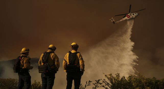 Un helicóptero descarga agua desde un helicóptero sobre el incendio Palisades en Mandeville Canyon el sábado 11 de enero de 2025 en Los Ángeles. 