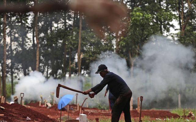 Un sepulturero prepara una tumba para una víctima de COVID-19 en el cementerio de Cipenjo en Bogor