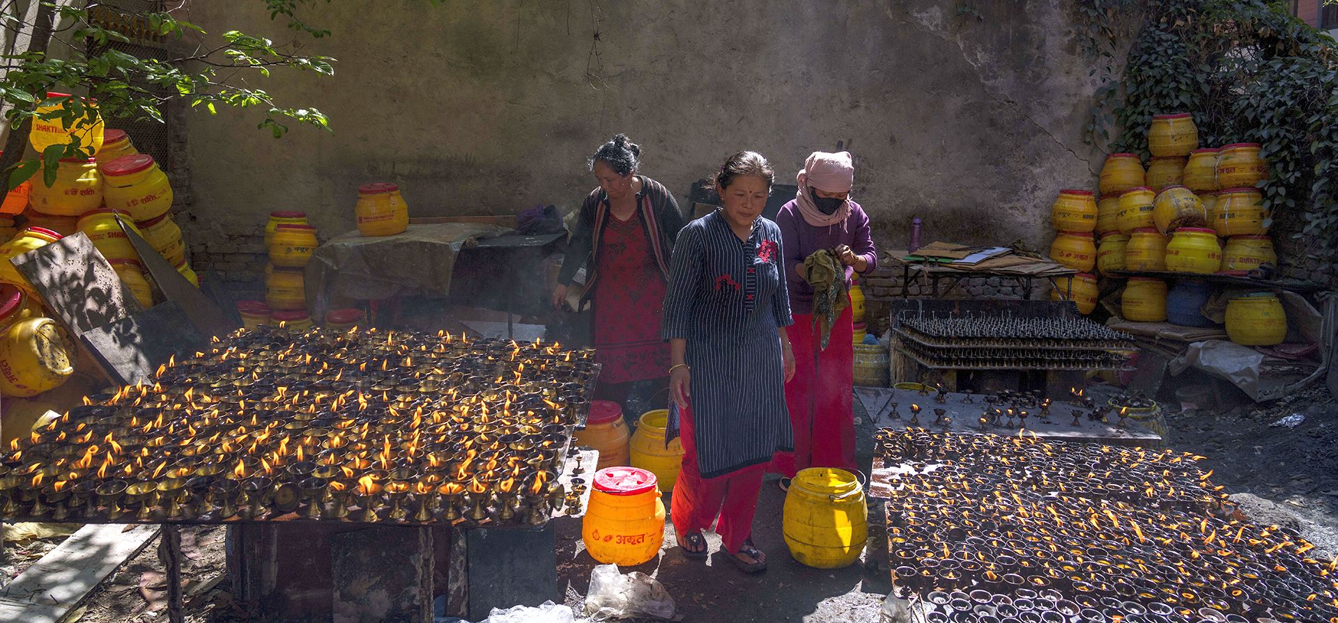 Vendedores descansan mientras venden lámparas de mantequilla durante el festival Temal en Boudhanath Stupa en Katmandú, Nepal, el miércoles 5 de abril de 2023. (Foto AP/Niranjan Shrestha)